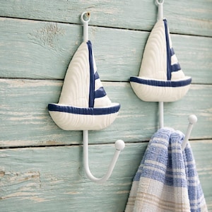 Könnte beinhalten: Ein Set aus drei Keramikbechern mit gesprenkelter, matter Oberfläche. Die Becher sind in Creme-, Hellgrau- und Dunkelgrautönen gehalten. Jeder Becher hat ein schlichtes, minimalistisches Design und einen abgerundeten Henkel.