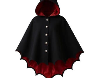 May include: A black cape with a red satin lining and a bat-wing hemline. The hooded cape features small horns and is fastened with four pearl-like buttons. The cape is designed for costume or cosplay use.
