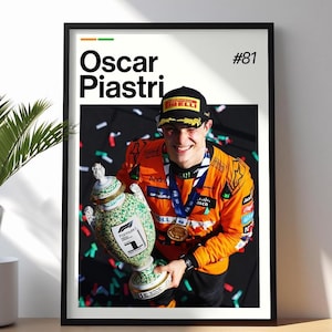 Puede incluir: Impresión enmarcada de Oscar Piastri, piloto de Fórmula 1, sosteniendo un trofeo. La impresión tiene un marco negro e incluye el texto "Oscar Piastri" y el número "#81". El piloto lleva una gorra negra y un traje de carreras naranja.