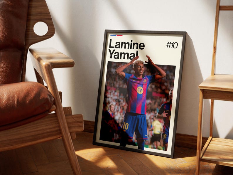 May include: Framed poster featuring a soccer player in a blue and red uniform, with the name "Lamine Yamal" and the number "10" displayed. The player is celebrating with arms raised. The poster is in a black frame.