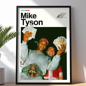 May include: Framed poster featuring Mike Tyson holding cash and wearing a championship belt. The poster has the name "Mike Tyson" in bold black letters with a green and red stripe above the name. A signature is in the upper right corner.