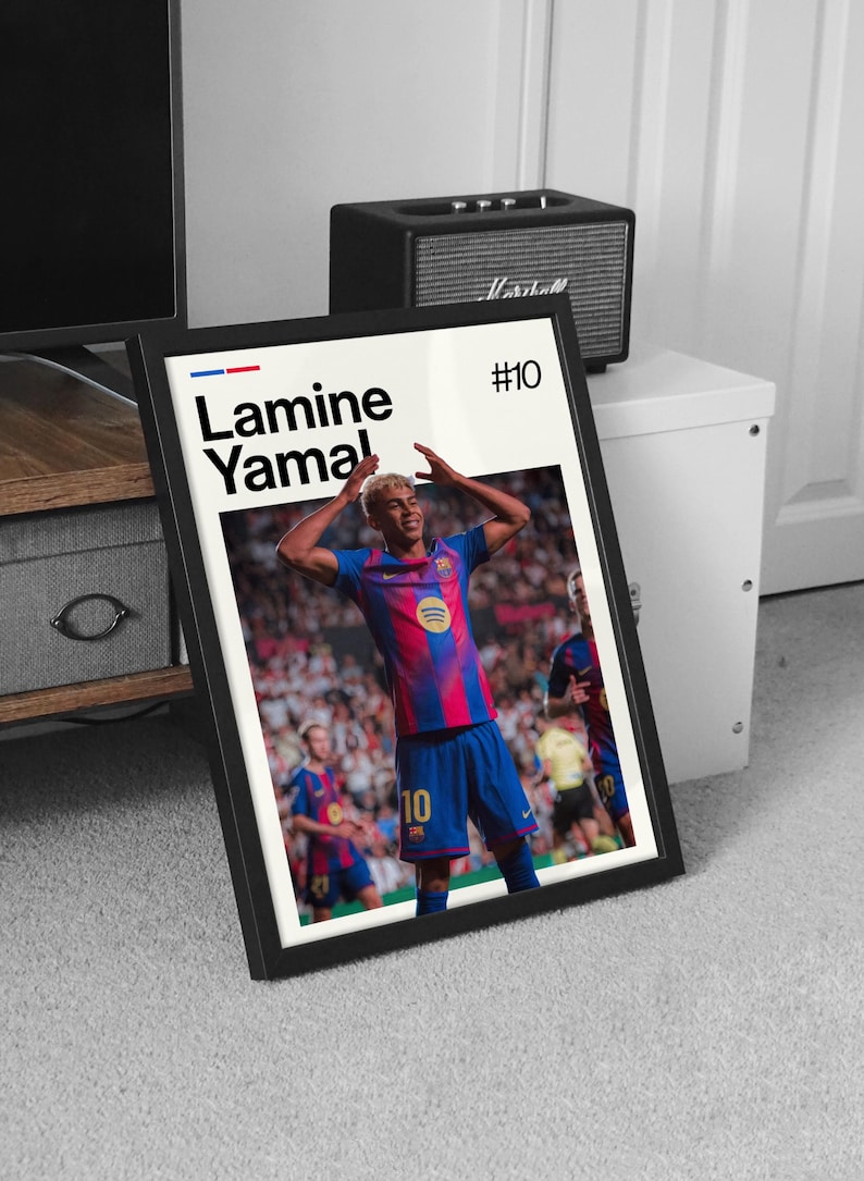 May include: Framed poster featuring a soccer player in a blue and red jersey with the number 10. The poster includes the player's name, "Lamine Yamal," and the number "#10" in the top right corner. The background shows a stadium filled with spectators.