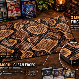 May include: A rectangular playmat featuring a brown and black snakeskin pattern. The mat has a 3 mm thickness and measures 24 inches by 14 inches. It includes a smooth surface with clean edges and a non-slip rubber backing for stability.