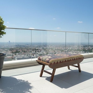 Wooden entryway bench with tribal upholstery placed on terrace with city view