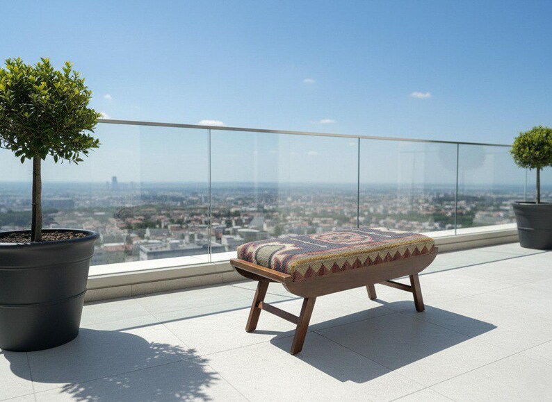 Wooden entryway bench with tribal upholstery placed on terrace with city view