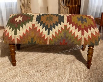 Banco otomano de madera tapizado con kilim hecho a mano, reposapiés con estampado tribal bohemio, asiento rústico para entrada o dormitorio.