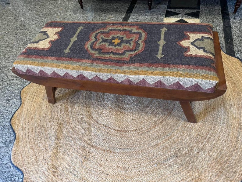Close-up detail of tribal kilim upholstery on solid wood bench seat
