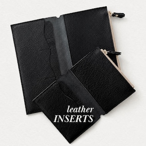 Könnte beinhalten: Zwei schwarze, texturierte Leder-Organizer mit Reißverschluss und Innentaschen. Der kleinere Organizer liegt vor dem größeren, wobei der weiße Text "leather INSERTS" deutlich auf der Vorderseite des kleineren Artikels aufgedruckt ist.