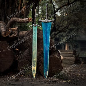 May include: Two fantasy swords with ornate hilts and blades. One sword has a light green blade, the other a blue blade. The swords are displayed against a backdrop of logs and a forest setting. The text "Engraves Tycon" is visible.