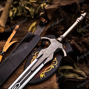 May include: A detailed image of a fantasy sword with a silver blade and intricate hilt design. The sword rests on a wooden surface, next to a black leather sheath and a decorative shield with gold accents. The overall aesthetic is medieval and fantasy-themed.