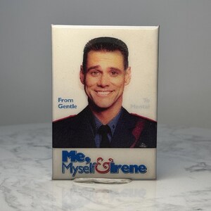 May include: Rectangular magnet featuring a smiling man in a suit. The magnet has the text "From Gentle To Mental" and "Me, Myself & Irene" in blue and white lettering. The image is set against a neutral background.
