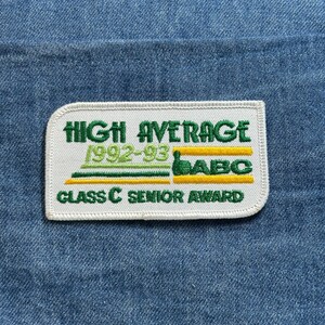 May include: A rectangular patch with the text "HIGH AVERAGE 1992-93 ABC CLASS C SENIOR AWARD" in green and yellow on a white background. The patch is sewn onto a blue denim fabric.