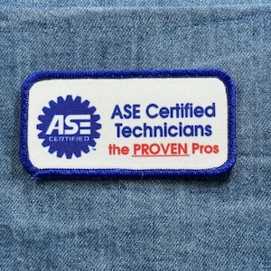 May include: A rectangular patch with a white background and a blue border. The patch features the ASE logo and the text "ASE Certified Technicians the PROVEN Pros" in blue and red.