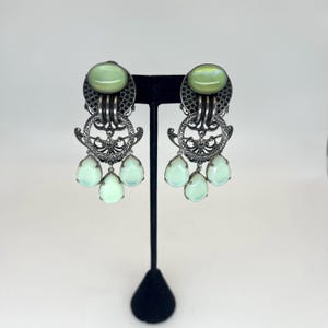 Brincos de pressão JL BLIN com pingentes de vidro verde e metal prateado.