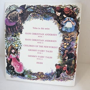 Puede incluir: Una portada de libro vintage con ilustraciones de personajes de cuentos de hadas. La portada incluye los t&iacute;tulos "Hans Christian Andersen", "Grimm's Fairy Tales" y "Heidi". La obra de arte est&aacute; enmarcada por un borde decorativo de hojas y flores.