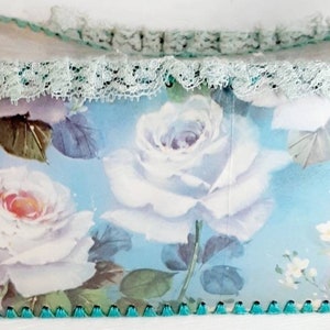 May include: A blue and white floral patterned box with a lace trim and a green scalloped edge.