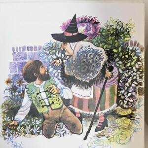 Puede incluir: Ilustraci&oacute;n de un libro infantil que representa a una bruja con un sombrero negro y un joven con un chaleco verde. La bruja se&ntilde;ala al hombre, que est&aacute; arrodillado en un jard&iacute;n con flores y follaje.