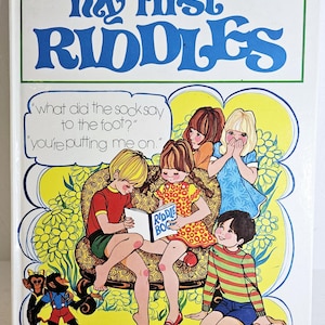 Puede incluir: Un libro infantil vintage titulado "My First Riddles" de Paul Hamlyn. La portada presenta una colorida ilustración de niños leyendo un libro de acertijos, con el texto "What did the sock say to the foot?" y "You're putting me on."