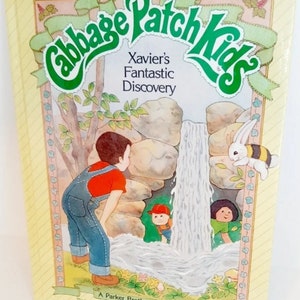 May include: A yellow book cover with a green Cabbage Patch Kids logo. The title is "Xavier's Fantastic Discovery". The cover features a cartoon illustration of a boy looking at a waterfall with a rabbit and a bee.