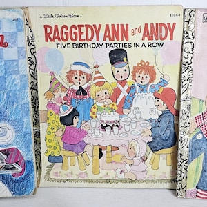May include: Three vintage "Little Golden Book" children's books featuring Raggedy Ann and Andy. The titles include "Raggedy Ann and the Cookie Snatcher," "Raggedy Ann and Andy: Five Birthday Parties in a Row," and "Raggedy Ann and Andy and the Rainy-Day Circus."