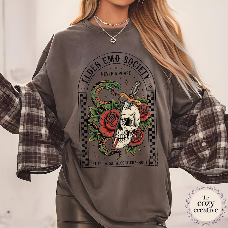 May include: Gray sweatshirt with a graphic featuring a skull bisected by a dagger, a green snake, and red roses. Text reads "ELDER EMO SOCIETY NEVER A PHASE" and "EST 1990S METALCORE CRASHOUT".