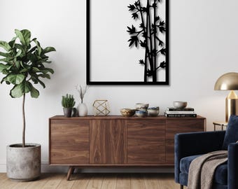 May include: A rectangular black metal wall art piece featuring a laser-cut design of bamboo stalks and leaves. The artwork is framed in a thin black border and displays a silhouette of plant stems against a plain white background.