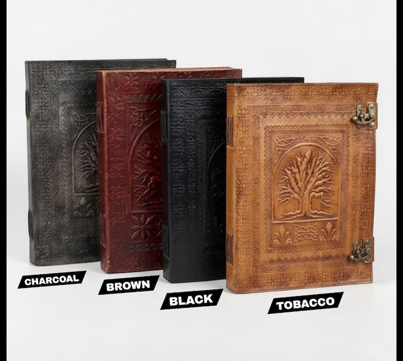 May include: Four leather journals in charcoal, brown, black, and tobacco shades. Each journal has an embossed tree design and a metal clasp. The journals are upright, highlighting their intricate details and varied colours.