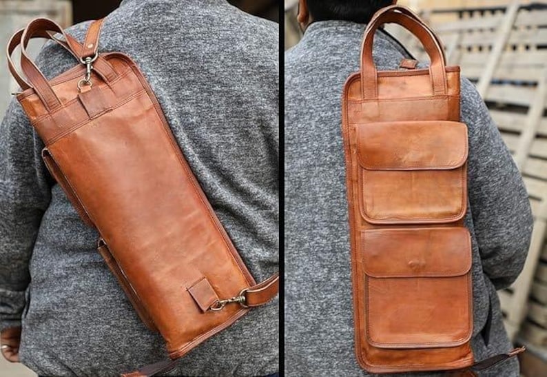 May include: A brown leather quiver with a shoulder strap and multiple pockets. The quiver is designed to be worn over the shoulder and has a rectangular shape with a flap closure. The leather has a natural, textured appearance.