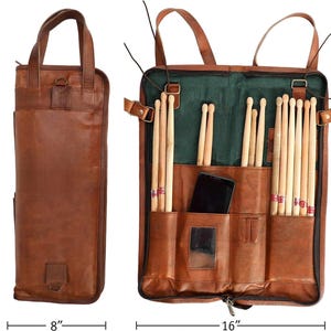 Puede incluir: Una funda de baquetas de cuero marrón, de 51 cm de alto, 20 cm de ancho cerrada y 41 cm de ancho abierta. La funda tiene un asa y una bandolera. En el interior, contiene baquetas y un smartphone. El interior es verde.