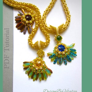Può includere: Due collane di perline dorate con pendenti elaborati. I pendenti sono fatti di perline e presentano una varietà di colori, tra cui blu, verde e oro. Le collane sono su uno sfondo bianco.