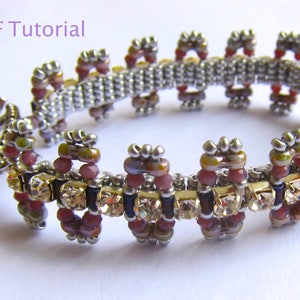 May include: A beaded bracelet with a silver clasp and a pattern of alternating rows of small, colourful beads and larger, clear crystals.