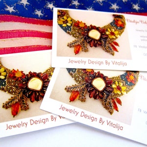 May include: Three business cards with a photo of a beaded necklace with a large amber-colored stone in the center. The text on the cards reads "Jewelry Design By Vitalija" and includes contact information for the designer.