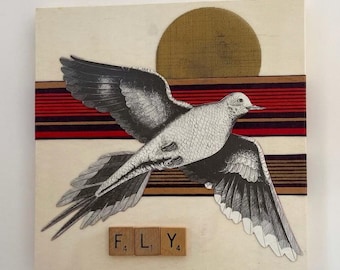 May include: A wooden art piece featuring a black and white illustration of a bird in flight. The bird is set against a backdrop of a red and brown striped band and a gold-colored sun. The word "FLY" is spelled out with wooden letter tiles.