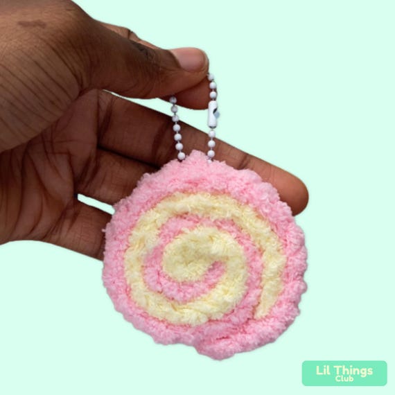 A teeny hand-crocheted Swiss roll keychain that looks good enough to eat — charming amigurumi craft you genuinely can't get at a mall.