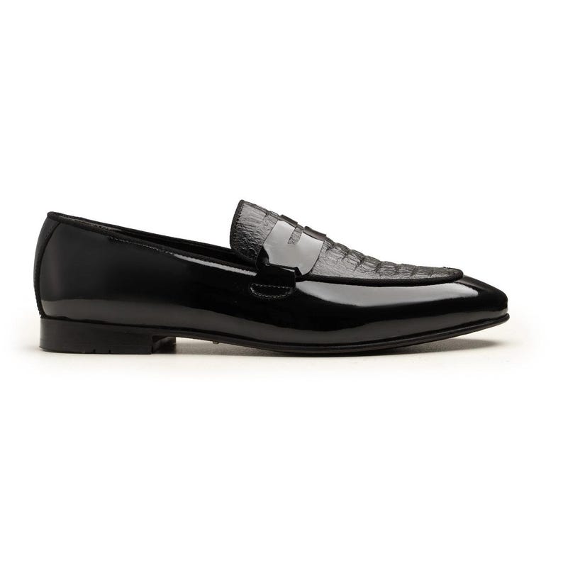 May include: A black leather loafer with a glossy finish. The shoe features a textured vamp and a sleek, pointed toe. The design includes a low heel and a slip-on style, suitable for formal or semi-formal occasions.