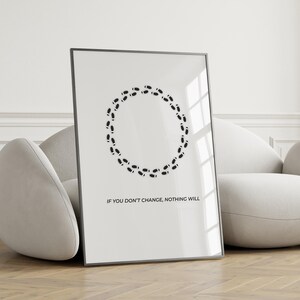 May include: A framed print with a white background, displaying a circle of black footprints. The text "IF YOU DON'T CHANGE, NOTHING WILL" is printed in black below the circle. The frame is black.