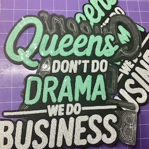 May include: A black fabric patch featuring the text "Queens DON'T DO DRAMA WE DO BUSINESS" in mint green and white sequins. The word "Queens" is in mint green, "DON'T DO DRAMA" is in mint green, and "WE DO BUSINESS" is in white, all on a black base.