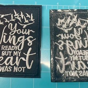 May include: Two black embroidered patches with white text and designs. One patch reads "Your Wings Were Ready But My Heart Was Not" with a feather and birds. The other patch is a mirror image.