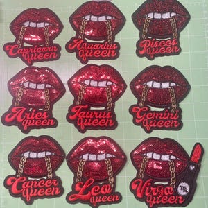 Könnte beinhalten: Gestickte Aufnäher mit roten Paillettenlippen und goldenen Kettenakzenten. Jeder Aufnäher zeigt ein anderes Sternzeichen und das Wort "queen" in roter Schrift. Zeichen sind Steinbock, Wassermann, Fische, Widder, Stier, Zwillinge, Krebs, Löwe und Jungfrau.