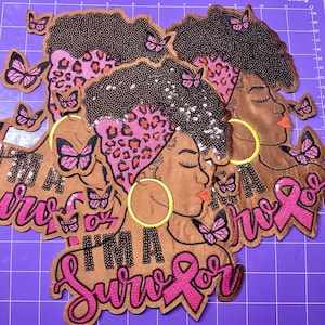 May include: A set of embroidered patches featuring a profile of a person with dark curly hair, a pink leopard print headwrap, and large yellow hoop earrings. The patches include pink butterflies and the text I'M A SURVIVOR with a pink ribbon.
