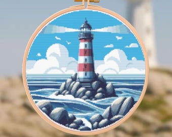 Puede incluir: Bordado de punto de cruz de un faro con rayas rojas y blancas, sobre un cielo azul con nubes blancas y olas del océano. El faro está en una isla rocosa, enmarcado en un bastidor de bordado de madera.