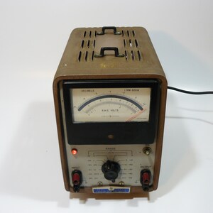 May include: A vintage brown and black analog voltmeter with a dial labeled "RMS Volts" and a knob labeled "Range". The meter has a black cord attached to it.