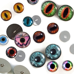 May include: Assortment of colorful glass eyes with silver trim, some with a butterfly design, and plain silver buttons.