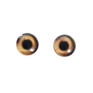 Puede incluir: Dos ojos de vidrio marrones con pupilas negras, adecuados para la fabricaci&oacute;n de mu&ntilde;ecas u otros proyectos de artesan&iacute;a.