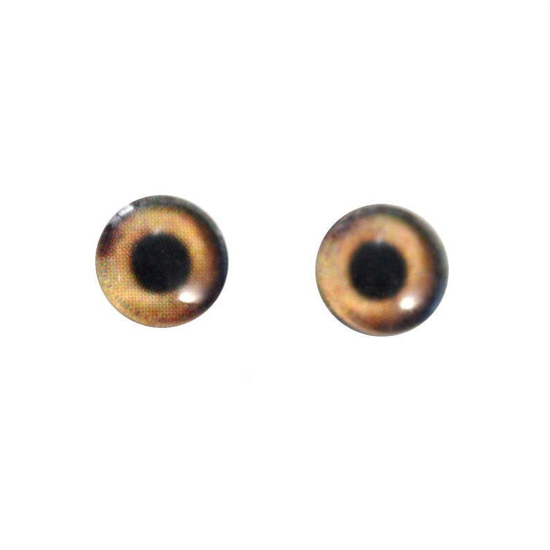 Puede incluir: Dos ojos de vidrio marrones con pupilas negras, adecuados para la fabricaci&oacute;n de mu&ntilde;ecas u otros proyectos de artesan&iacute;a.