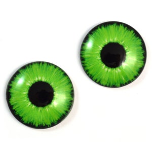 May include: Two green glass eyes with black pupils. The eyes are round and have a realistic look.