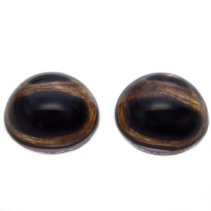 Puede incluir: Dos ojos de seguridad de plástico marrón y negro con pupila negra e iris marrón. Los ojos son redondos y tienen un acabado brillante.
