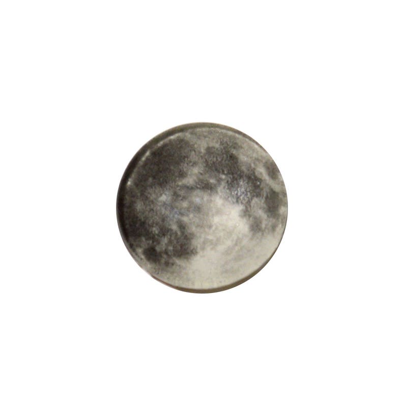 May include: A close-up of a round, gray and white moon-shaped object. The object has a textured surface that resembles the surface of the moon.