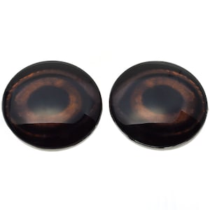 May include: Two brown plastic safety eyes with black pupils and a brown iris. The eyes are round and have a glossy finish.