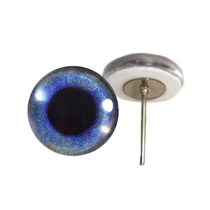 May include: A pair of blue glass eyes with a black pupil and a silver pin on the back. The eyes are for crafts and are approximately 1 inch in diameter.